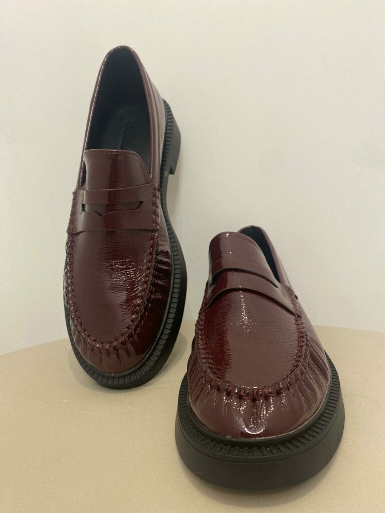 Photo des mocasin VAL sur un fond blanc. Mocassin de couleur bordeaux vernis à semelle légèrement compensées noires.